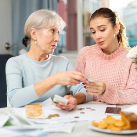 Young woman receiving money from her mother